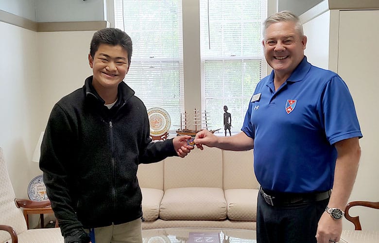 Col. David L. Coggins, USMC (Ret.), the President of Fork Union Military Academy, presents a challenge coin to a cadet in recognition of his exemplary performance of a task for which he had volunteered.